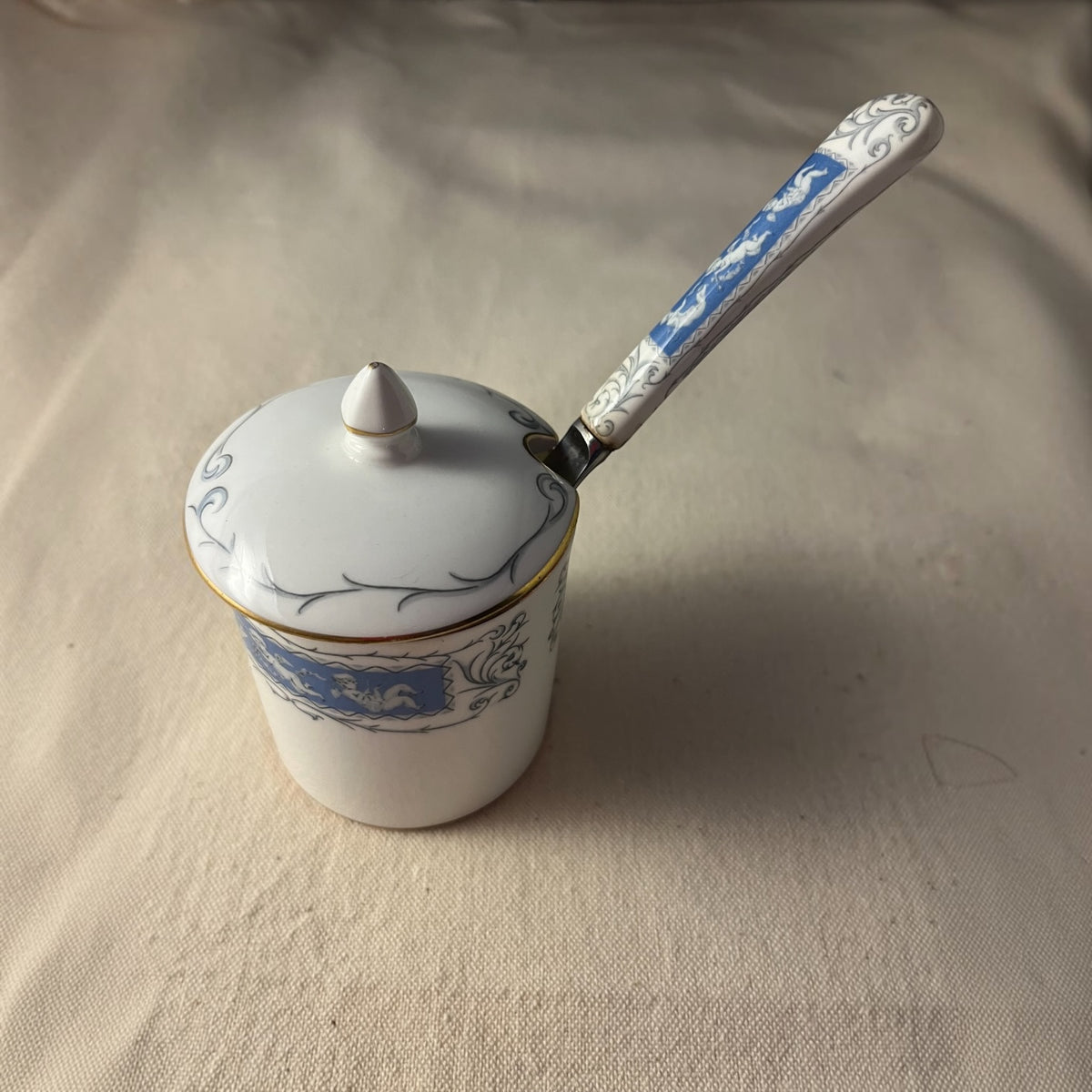 Mantequillero Coalport Revelry con tapa y cuchillo de mantequilla, porcelana blanca con banda azul de querubines, vista cenital