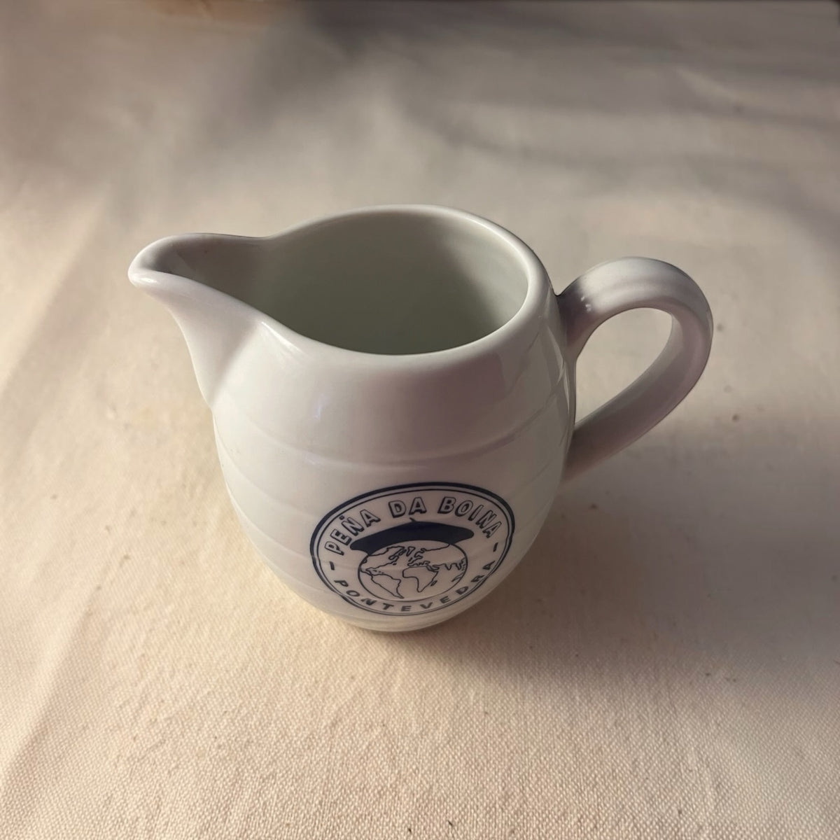 Jarra de vino porcelana blanca con sello azul Peña da Boina Pontevedra, vista lateral con asa