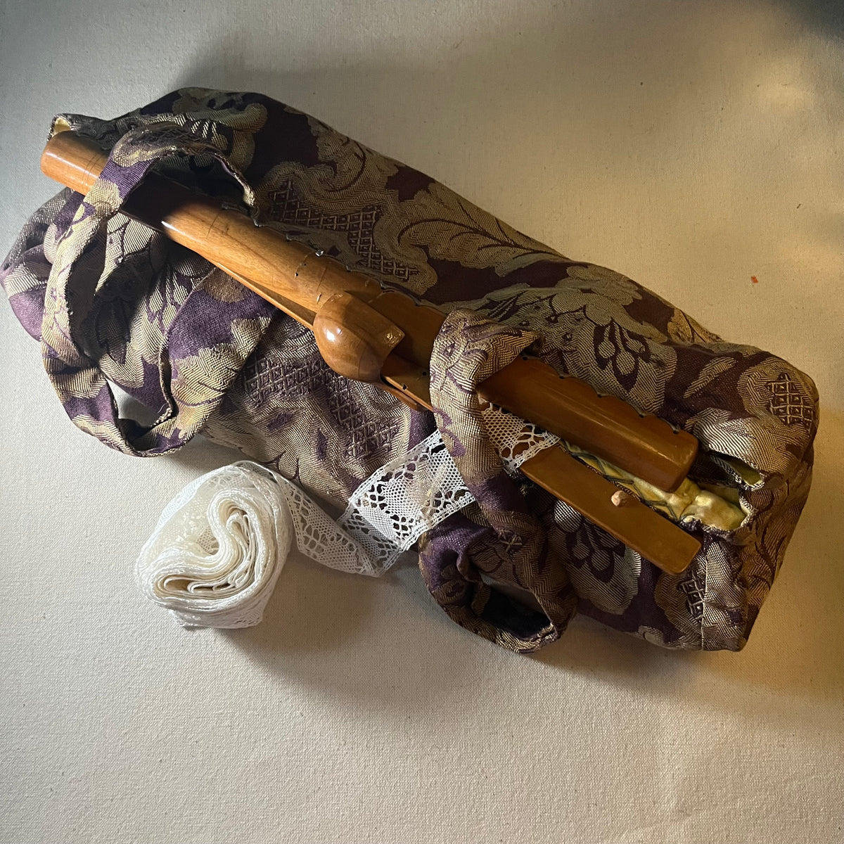 Bolsa de labor de brocado morado y dorado con mangos de bambú