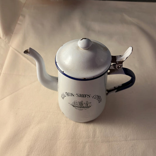 Cafetera esmaltada blanca con ribete azul y velero impreso, tapa abatible, vista lateral