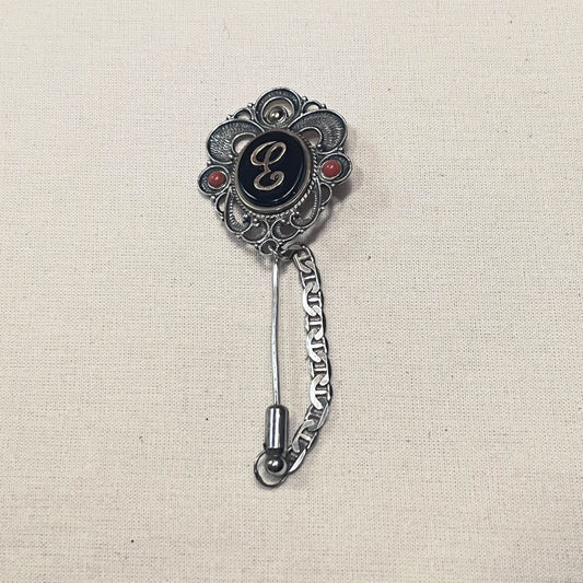 Alfiler de corbata de plata en filigrana con azabache, inicial E y dos cuentas de coral, con cadenilla
