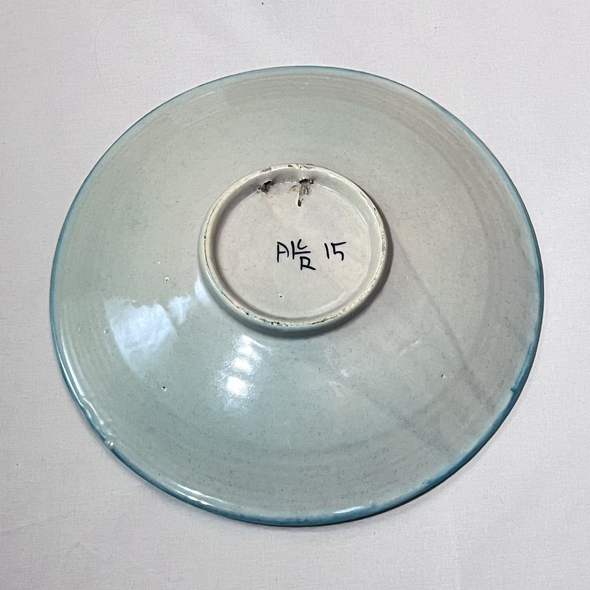 Reverso del plato de la perdiz con dos pequeños desconchones en el anillo del pie
